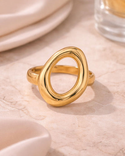 Gold ring on a light wooden surface with a blurred background