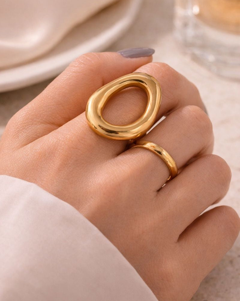 Gold ring on a hand with a neutral background