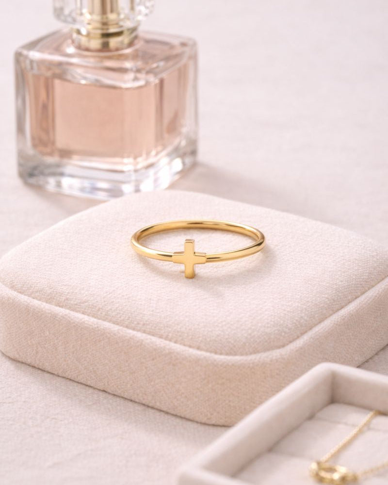 Gold ring on a jewelry box with a perfume bottle in the background